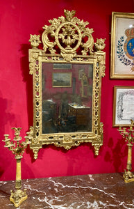 Miroir à fronton ajouré en bois redoré à motifs sculptés de vase fleuri. Epoque Transition - XVIII°