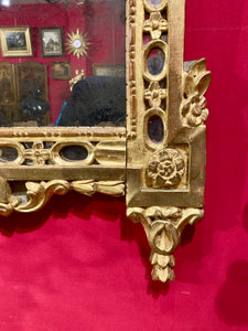 Miroir à fronton ajouré en bois redoré à motifs sculptés de vase fleuri. Epoque Transition - XVIII°