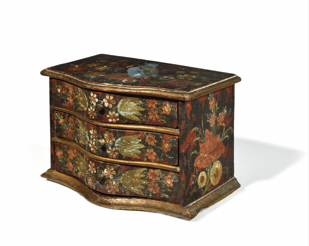 Petite commode serre-bijoux de forme mouvementée,en bois mouluré, peint et anciennement doré, ouvrant par trois tiroirs séparés de traverses, à riche décor polychrome d'oiseaux et fleurs. Italie, XVIIIe siècle. 14 x 22 cm